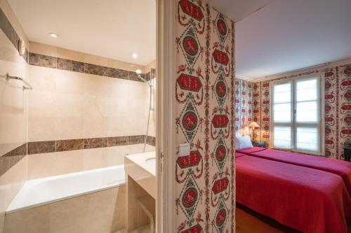 巴黎Hôtel Prince de Conti的一间卧室配有一张床和一个浴缸及淋浴