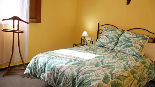 大加那利岛拉斯帕尔马斯Casa rural en San Mateo的一间卧室配有一张带绿色棉被的床