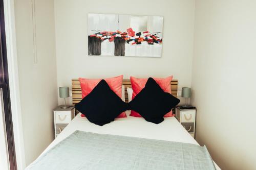 塔科龙特El Rincón del Mar的一间卧室配有红色和黑色枕头的床
