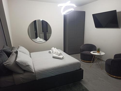 基耶蒂Le Mirage的一间卧室配有一张床、镜子和椅子