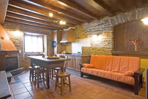 圣埃乌拉利亚德奥斯科斯Balcón de Oscos的厨房配有橙色沙发和桌子