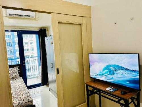 马尼拉Sea Residences by Jan & Val Alano的客厅配有餐桌上的平面电视