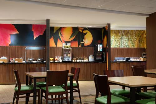 伦敦Fairfield Inn & Suites by Marriott London的一间带桌椅的餐厅和一间酒吧