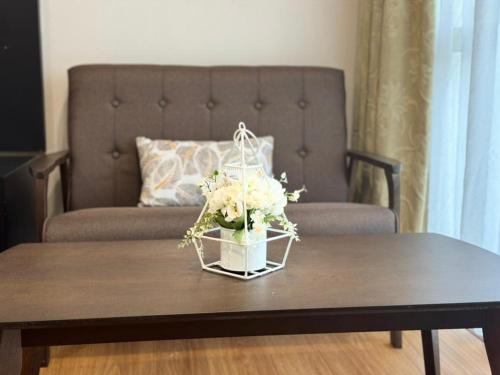 古晋Private Hotel Serviced Apartment MyHome Getway StayInn的花瓶,放在咖啡桌边,沙发上