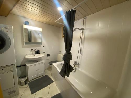 波朗特吕Apart'Hotel du Faubourg by Stay Swiss的带淋浴和盥洗盆的白色浴室