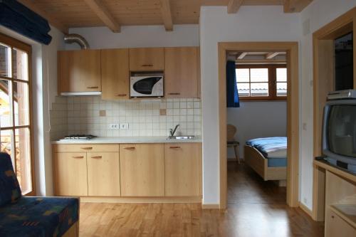 圣坎迪朵Valtnerhof的一个带木制橱柜的厨房和一张位于客房内的床