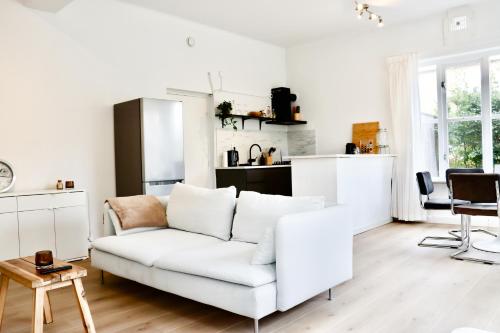 奈梅亨Boutique Appartement Oost的一间带白色沙发的客厅和一间厨房