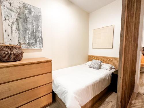 布尔哈索特apartamento muy próximo a Valencia的一间卧室配有一张床和一个木制梳妆台