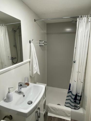 韦茅斯The Ocean Guesthouse的白色的浴室设有水槽和淋浴。