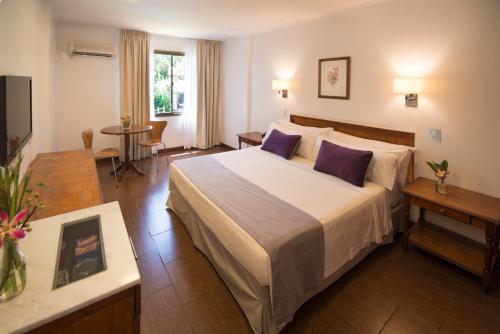 伊瓜苏港圣乔治酒店的酒店客房配有一张带紫色枕头的大床