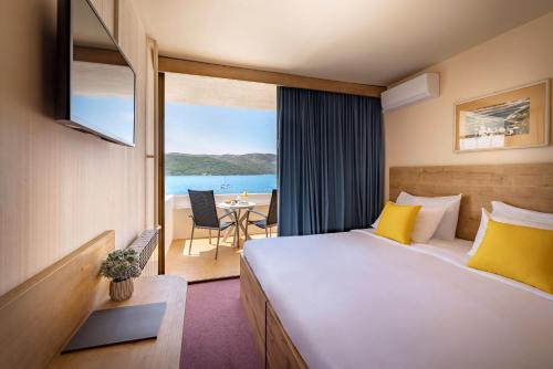 斯塔里格勒Arkada Hotel的酒店客房设有一张床,享有海景。
