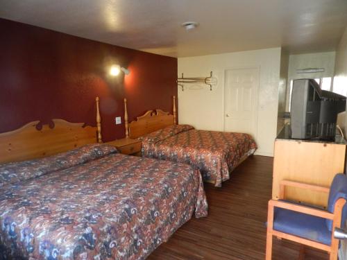 希塞德高地Seagem Motel and Apartments的酒店客房设有两张床和一台平面电视。