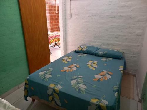 罗克萨恩斯培尼亚总统城ALQUILER TEMPORARIO LU-KA的一张带蓝色棉被的床,上面有叶子
