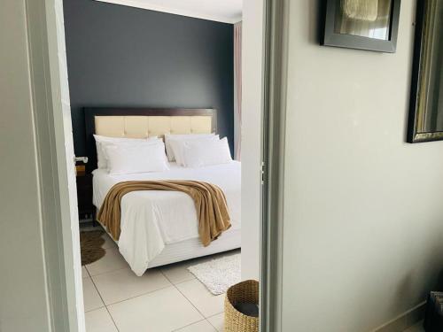 BoschrandGreen Valley Bliss的一间卧室配有带白色床单和枕头的床。