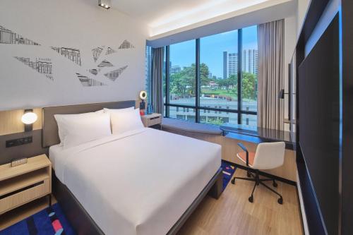 新加坡Aloft Singapore Novena的一间卧室配有一张床、一张书桌和一个窗户。