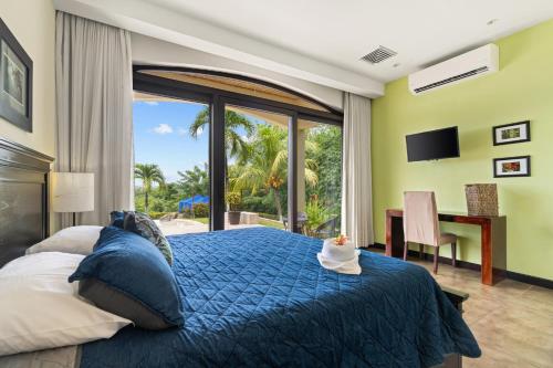 科克Villa Buena Onda All Inclusive的一间卧室配有一张带蓝色棉被的床和窗户。