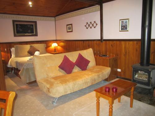 Howqua柳湖别墅酒店的客厅配有沙发和1张床