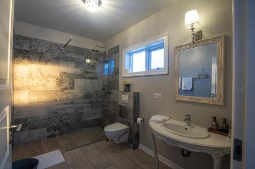 华姆斯唐吉慕课高级度假屋的一间带水槽、卫生间和镜子的浴室