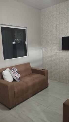 维索萨-杜塞阿拉Sua casa completa em Viçosa do Ceará的客厅里设有一张棕色沙发,配有窗户