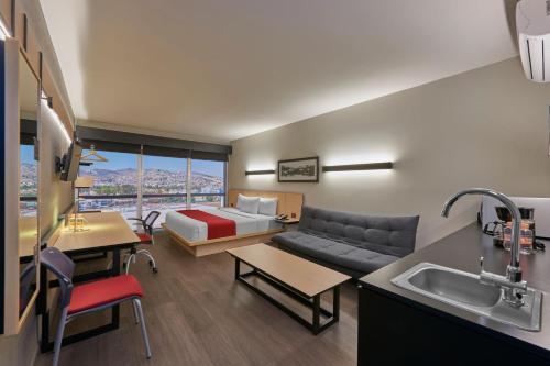 墨西哥城City Express Plus by Marriott Mundo E的客厅配有沙发和一张位于房间的床