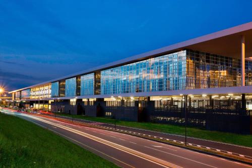 Ferno喜来登米兰马尔彭萨机场酒店及会议中心的前面有一条路的玻璃大建筑
