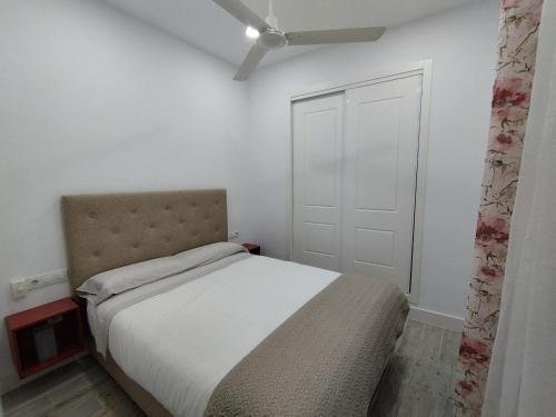 阿尔科斯-德拉弗龙特拉Apartamento Santa María的一间白色的卧室,配有床和门