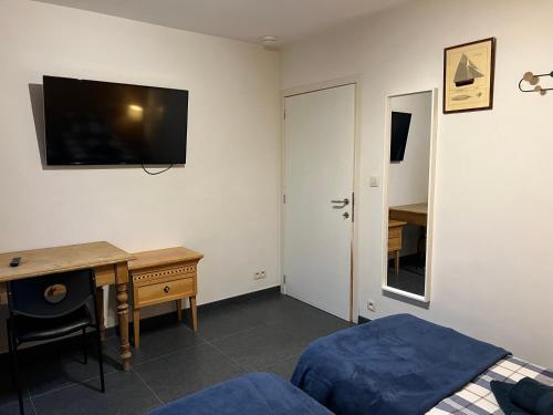 瓦夫尔Dame Cerise的一间卧室配有一张桌子和一张床,墙上配有电视。