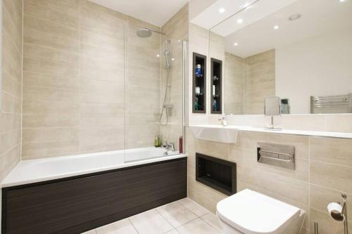 伦敦Greenwich O2 Apartment的带浴缸、卫生间和盥洗盆的浴室