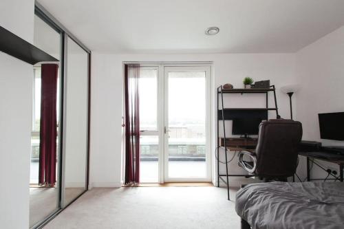 伦敦Greenwich O2 Apartment的一间卧室配有一张床、一张书桌和一个窗户。