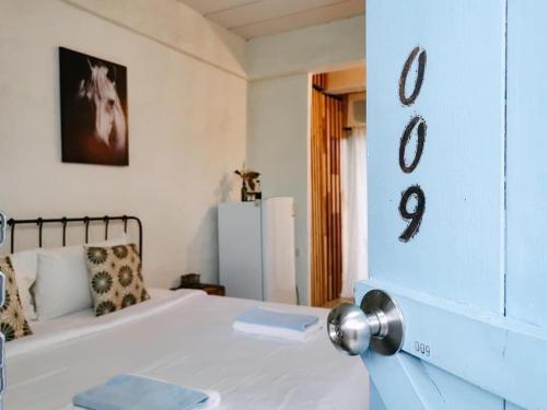 乌汶德亮旅馆的卧室配有白色的床,墙上有数字