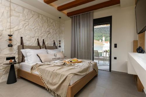 克里斯阿穆迪亚Ammothines Beach Suites的一间卧室设有一张带石墙的大床