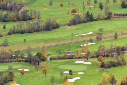 穆劳附近圣格奥尔根My Chalet In Murau的享有高尔夫球场和绿色山丘的空中景致
