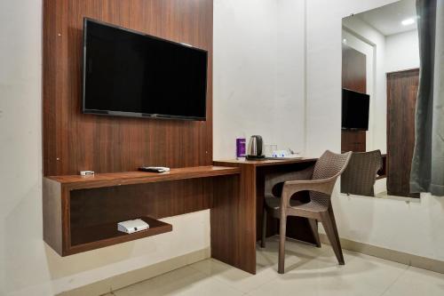 浦那hotel Fortune Suites Baner-- Indian nationals only的一间设有一张桌子的房间,墙上有一台电视机