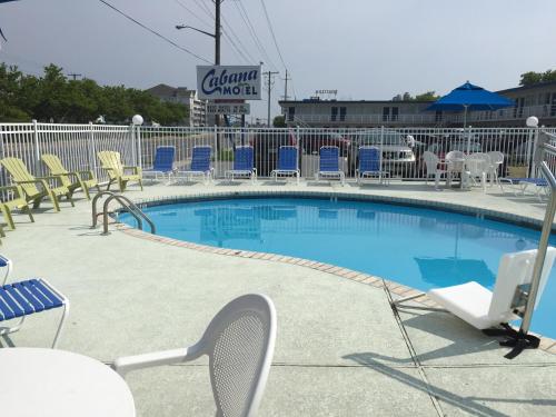 大洋城卡班纳汽车旅馆的一个带椅子的游泳池以及网球拍