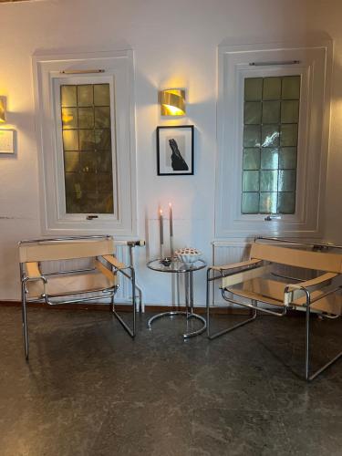 哥德堡Ewa & Maude Hotel Aston Villa的一间设有两把椅子和一张带蜡烛的桌子的房间