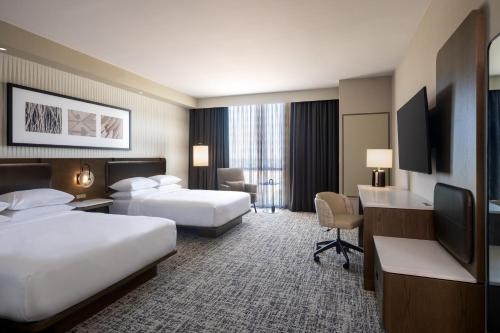 威奇托福尔斯Delta Hotels by Marriott Wichita Falls Convention Center的酒店客房配有两张床和一张书桌