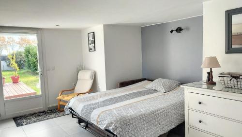 Plaisance-du-TouchCharmant Studio Cosy的卧室配有床、椅子和窗户。