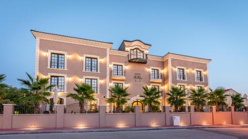 帕科坦Boutique Hotel Bora & Villas Garamm的一座白色的大建筑,前面有棕榈树