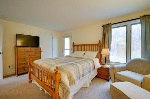 斯特拉顿Sunny Stratton Townhome about 1 Mi to Skiing!的一间卧室配有一张床、一把椅子和电视