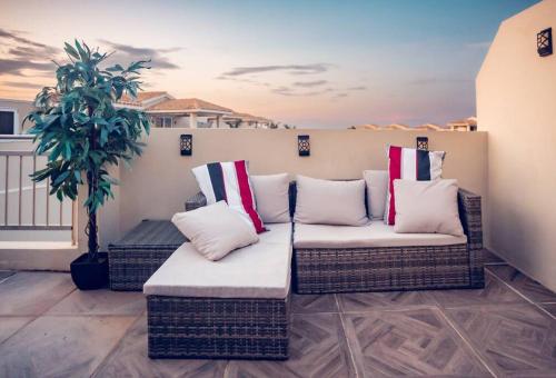 伊莎贝拉Paradise Coast PR Rooftop Suite的一个带柳条家具和盆栽的庭院