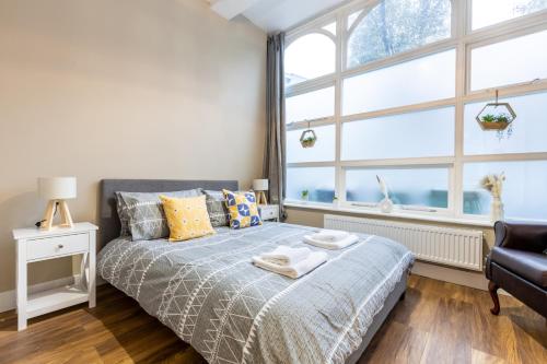 伦敦Modern 2BD Flat In Camden Town London的一间卧室设有一张床和大窗户