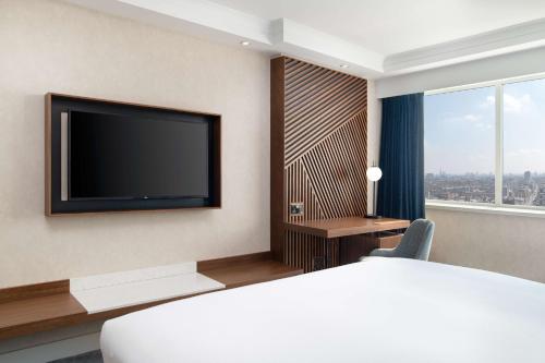 伦敦希尔顿伦敦大都会酒店的配有一张床和一台平面电视的酒店客房