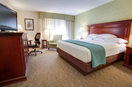 圣路易斯Pear Tree Inn St Louis Convention Center的配有一张床和一台平面电视的酒店客房