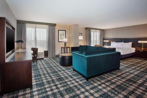 兰辛DoubleTree by Hilton Lansing的酒店客房,配有床和沙发