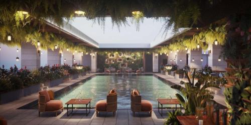 多哈DoubleTree by Hilton Doha Downtown的一座配有桌椅的酒店游泳池