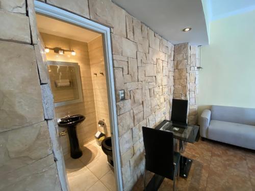 圣地亚哥AH Teatinos的浴室设有石墙、水槽和沙发