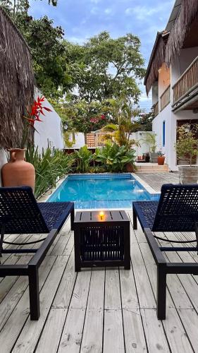 托兰克索Pousada Bem Te Vi Trancoso的一个带两把椅子的庭院和一个游泳池