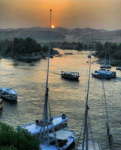 Aswân Reservoir Colonyبرنامج سياحي كامل داخل اسوان的日落时分在水中的小船