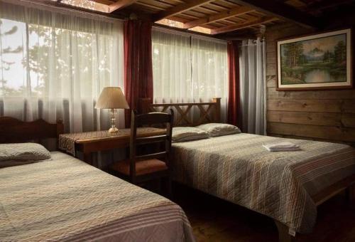 图里亚尔瓦Vista Turrialba Lodge的一间卧室配有两张床和一张带台灯的桌子