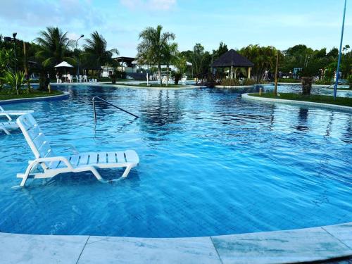 拉巴拉德纳圣米格尔Ap. Vista pra piscina - Iloa的水中带白色椅子的游泳池